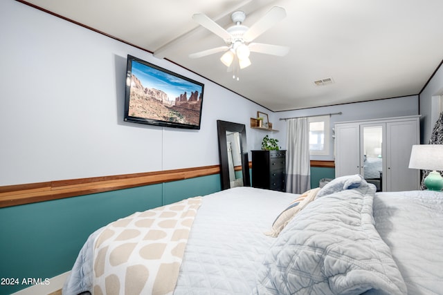 bedroom featuring ceiling fan and vaulted ceiling with beams