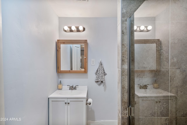 bathroom with vanity and a shower with door