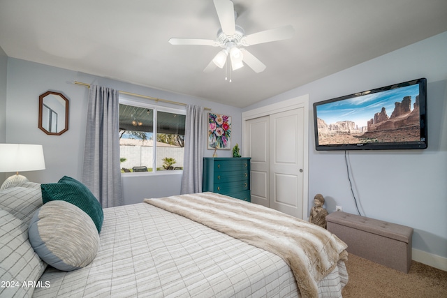 carpeted bedroom with a closet, lofted ceiling, and ceiling fan