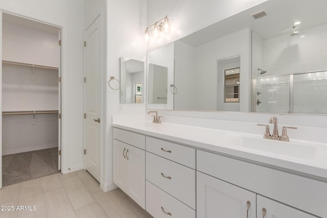 21640 E Roundup Way, Queen Creek, AZ 85142 - bathroom featuring a shower stall, double vanity, a walk in closet, and baseboards