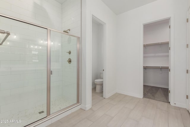 21640 E Roundup Way, Queen Creek, AZ 85142 - bathroom with a shower stall, toilet, a walk in closet, and baseboards