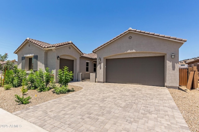 21640 E Roundup Way, Queen Creek, AZ 85142 - mediterranean / spanish-style home with a gate, an attached garage, stucco siding, and a tile roof
