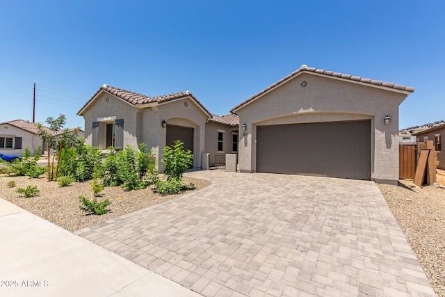 21640 E Roundup Way, Queen Creek, AZ 85142 - mediterranean / spanish home featuring a garage, stucco siding, decorative driveway, a tiled roof, and a gate