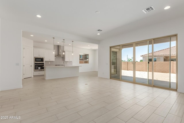 21640 E Roundup Way, Queen Creek, AZ 85142 - unfurnished living room featuring healthy amount of natural light, recessed lighting, and a sink