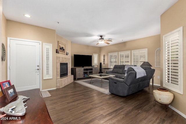 living room with a fireplace, dark hardwood / wood-style flooring, and ceiling fan