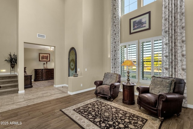 living area with light hardwood / wood-style floors and a high ceiling