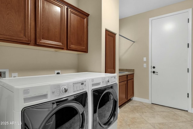 clothes washing area featuring washing machine and dryer and cabinets