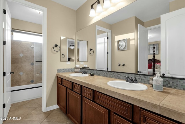 bathroom featuring tile patterned flooring, vanity, tiled shower / bath combo, and tasteful backsplash