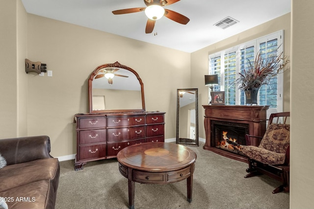 sitting room with ceiling fan and carpet