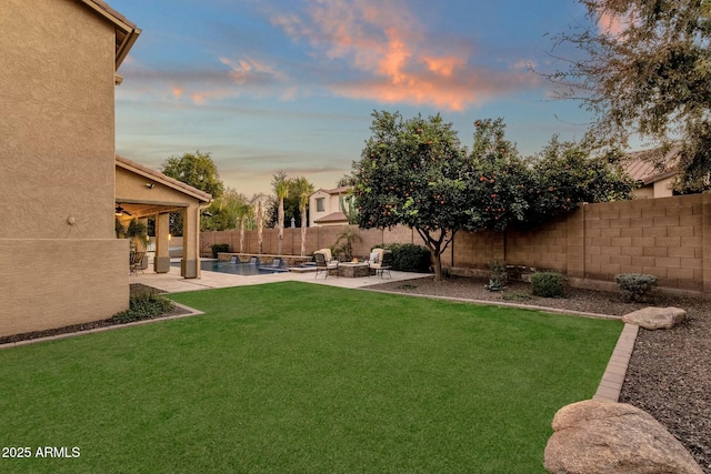 yard at dusk featuring a patio area and an outdoor fire pit