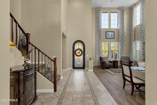 foyer entrance featuring a towering ceiling and a healthy amount of sunlight