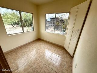 unfurnished bedroom featuring multiple windows, a closet, and light tile patterned floors