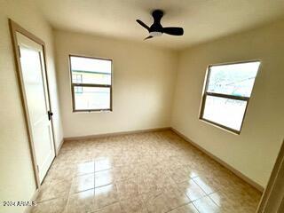 tiled spare room featuring ceiling fan