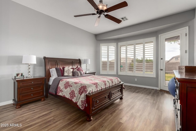 bedroom with access to exterior, visible vents, multiple windows, and dark wood-style floors