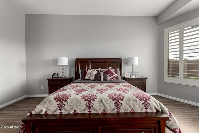 bedroom with dark wood-style flooring and baseboards