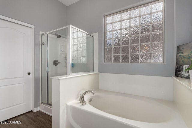 bathroom featuring a garden tub, wood finished floors, and a shower stall