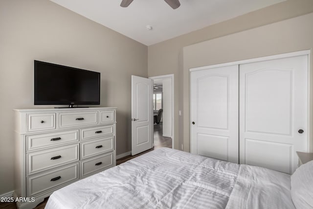 bedroom with a ceiling fan, baseboards, a closet, and wood finished floors