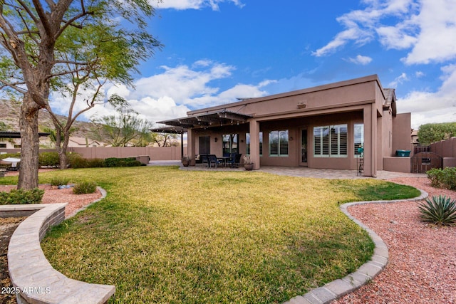 rear view of property with a patio area, fence, a lawn, and stucco siding