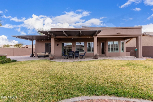 back of house with a patio, a lawn, and stucco siding