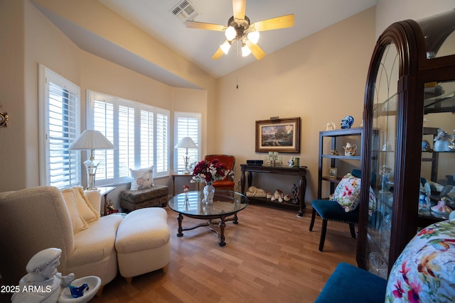 living room with hardwood / wood-style flooring, lofted ceiling, and ceiling fan