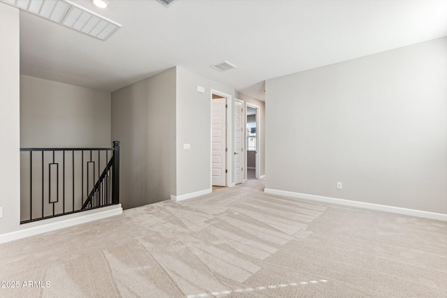 carpeted spare room featuring visible vents and baseboards