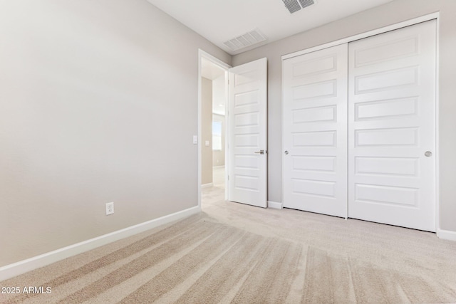 unfurnished bedroom featuring a closet, carpet flooring, visible vents, and baseboards