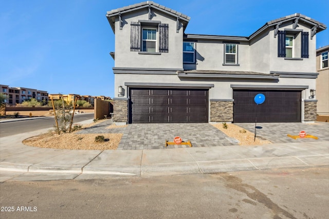 traditional-style home featuring a garage, stucco siding, stone siding, and a tile roof