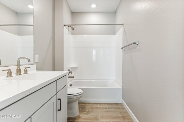 bathroom with bathtub / shower combination, wood finish floors, vanity, toilet, and baseboards