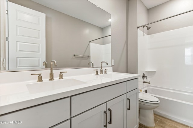 full bathroom featuring bathing tub / shower combination, a sink, toilet, and wood finished floors