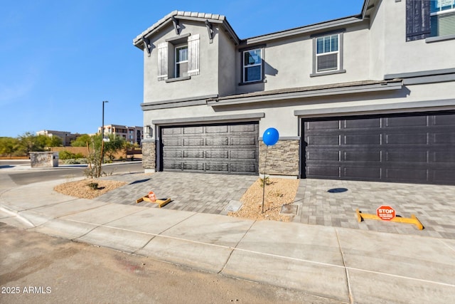view of front facade with a garage and stucco siding