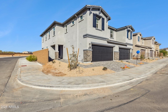 view of side of property with stucco siding, stone siding, and an attached garage