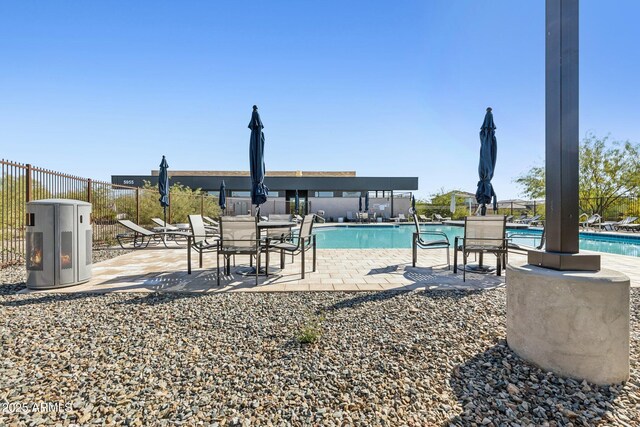 community pool with a patio and fence