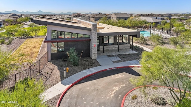 back of property featuring a patio, a residential view, stucco siding, and fence