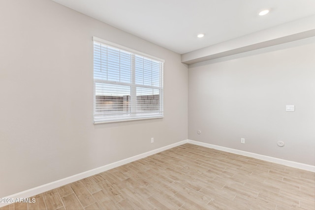 spare room with baseboards, light wood-type flooring, and recessed lighting