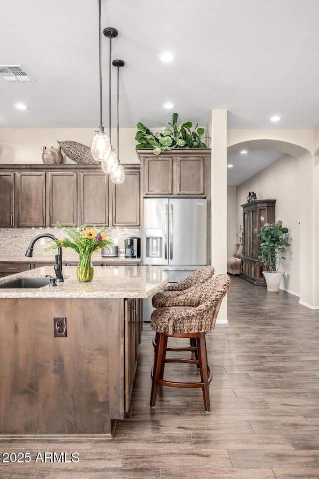 1822 N Waverly, Mesa, AZ 85207 - kitchen with arched walkways, wood finished floors, light stone counters, tasteful backsplash, and hanging light fixtures