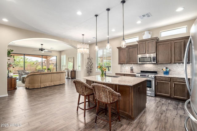 1822 N Waverly, Mesa, AZ 85207 - kitchen featuring appliances with stainless steel finishes, arched walkways, open floor plan, tasteful backsplash, and dark wood-style flooring