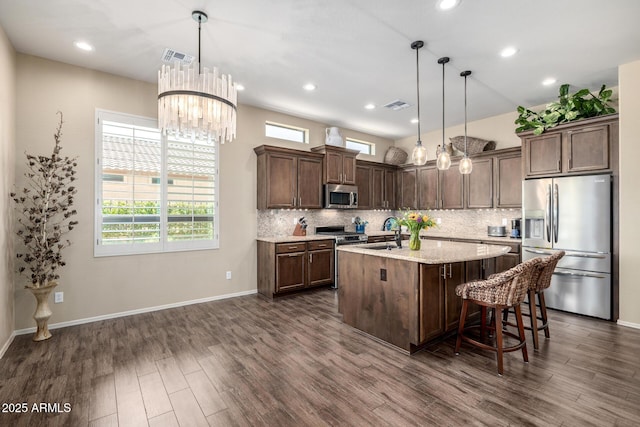 1822 N Waverly, Mesa, AZ 85207 - kitchen featuring appliances with stainless steel finishes, dark wood-style flooring, a kitchen island with sink, tasteful backsplash, and recessed lighting