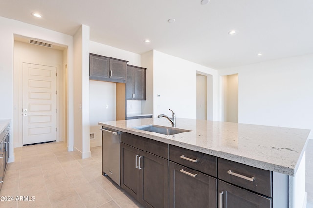 kitchen with sink, dishwasher, light stone counters, tasteful backsplash, and an island with sink