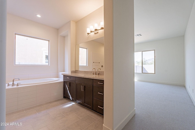 bathroom featuring vanity and tiled bath