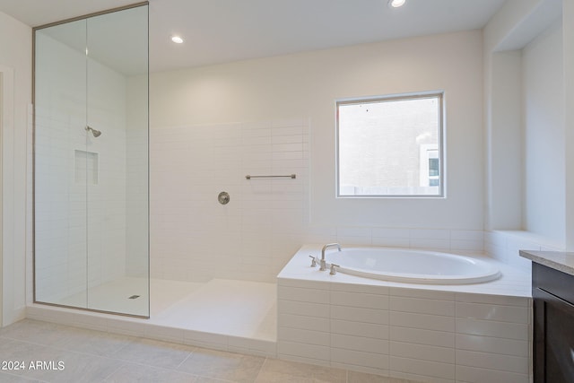 bathroom featuring plus walk in shower, vanity, and tile patterned floors