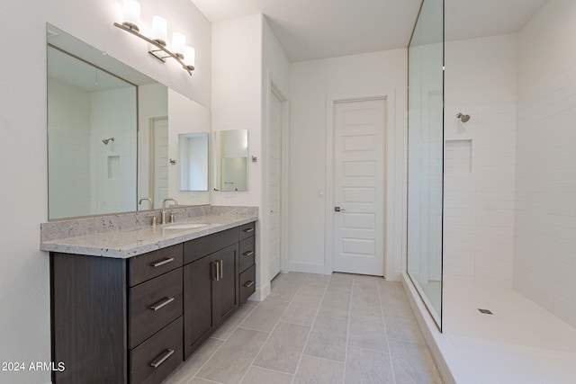 bathroom with vanity and a tile shower