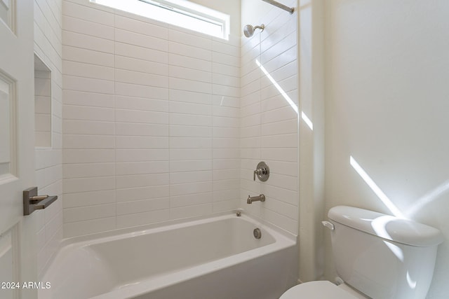 bathroom with tiled shower / bath and toilet