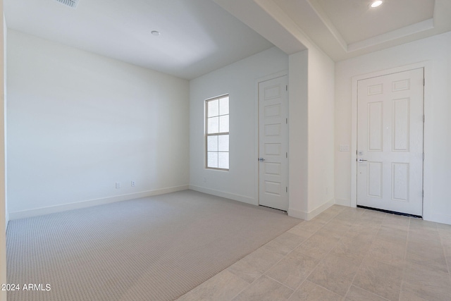 spare room featuring light colored carpet