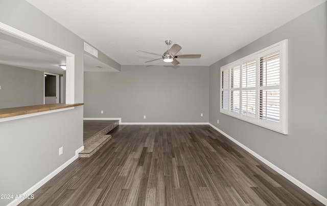 unfurnished living room featuring ceiling fan and dark wood-type flooring