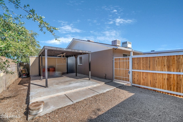 rear view of property with a carport and cooling unit