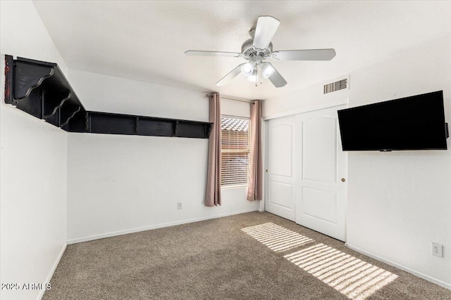 unfurnished bedroom with carpet floors, a closet, a ceiling fan, and baseboards