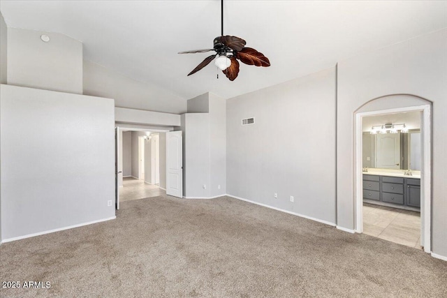 spare room with light colored carpet, ceiling fan, lofted ceiling, and baseboards
