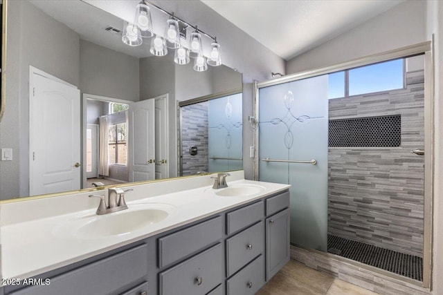 bathroom featuring a shower stall, double vanity, tile patterned flooring, and lofted ceiling