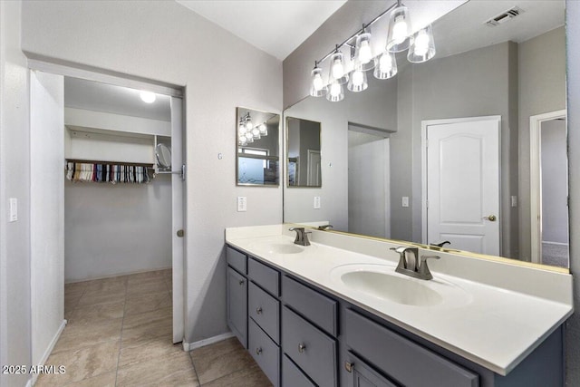 full bath featuring double vanity, baseboards, and tile patterned floors