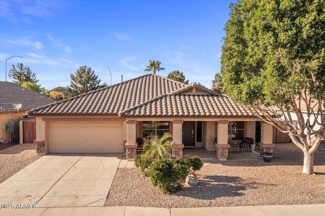 view of front of home with a tiled roof, an attached garage, driveway, and stucco siding